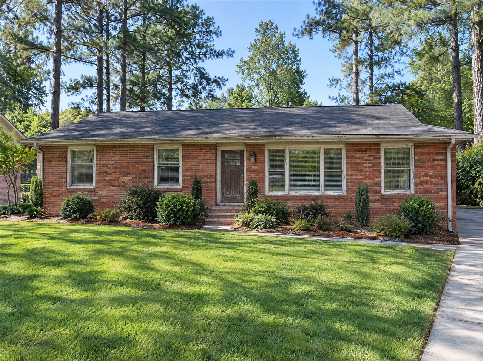 Ranch house with original orange-red brick and worn trim