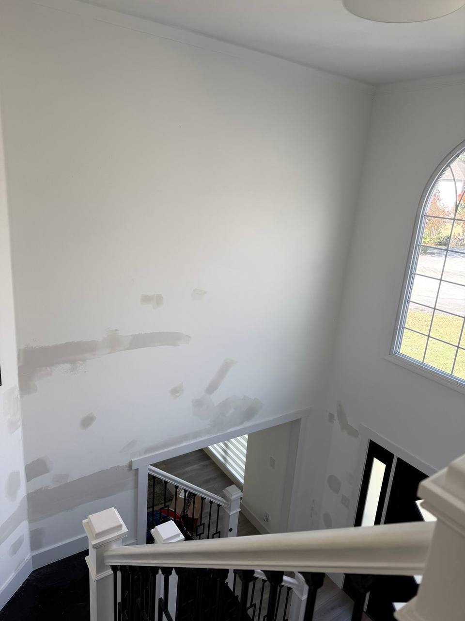 Stairwell wall with drywall patches ready for paint
